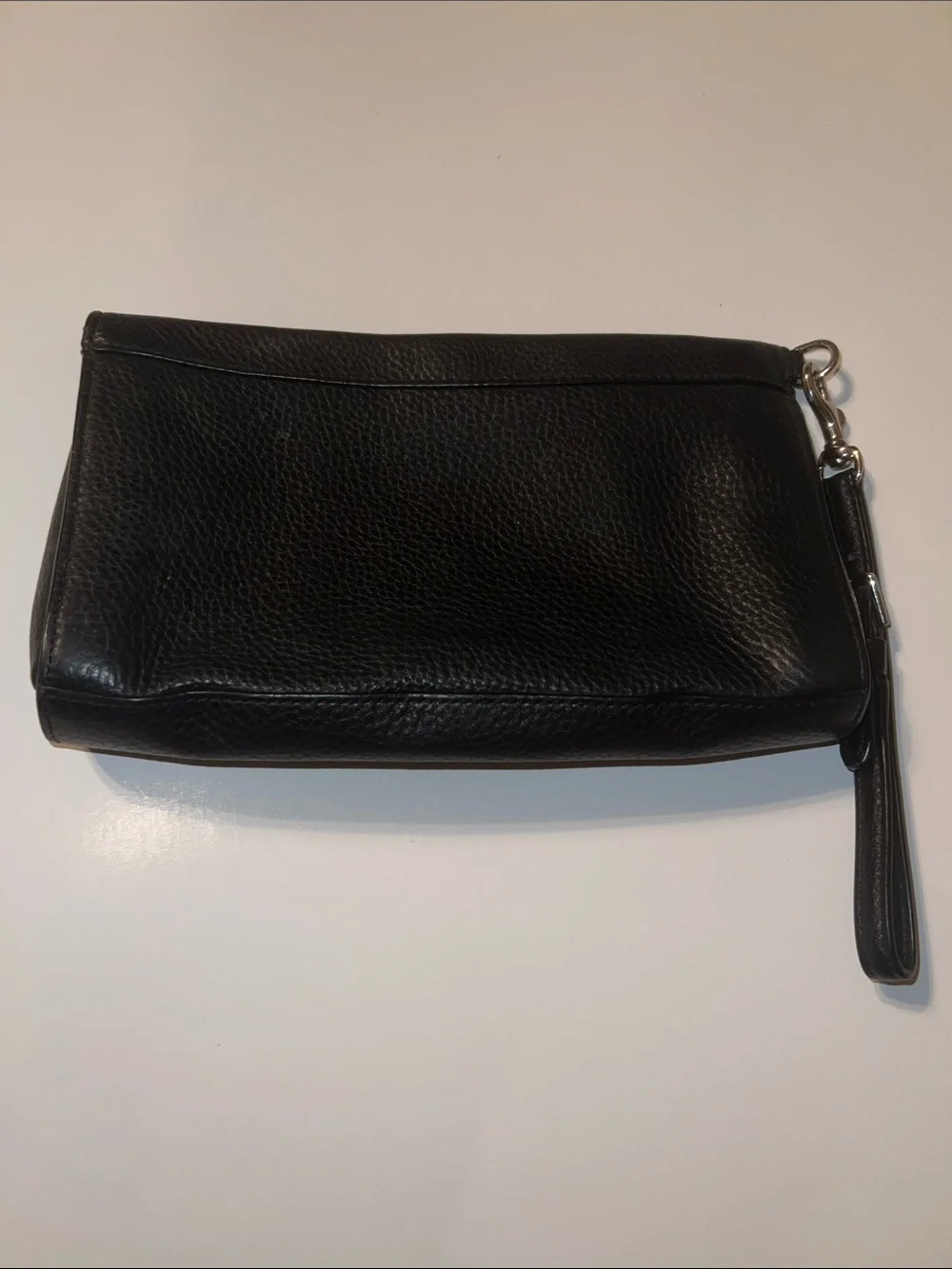 Coach Black Pebbled Leather Wristlet featuring silver hardware and a top zipper.